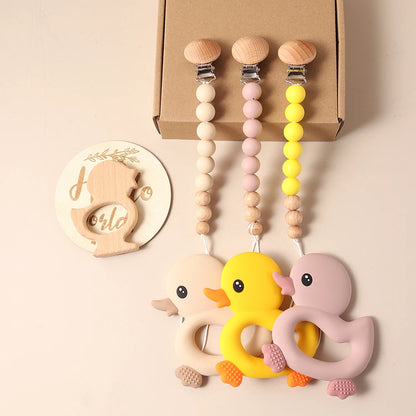 Baby giftset – eend bijtring, speenkoord, slabbetje & houten rammelaar – kraamcadeau in geschenkdoos